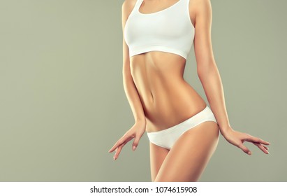  Perfect slim toned young body of the girl . An example of sports , fitness or plastic surgery and aesthetic cosmetology.

