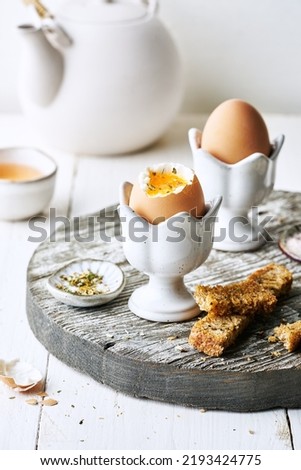 Perfect soft boiled egg in an egg cup with toast breakfast on the table. Traditional food for a healthy breakfast.
