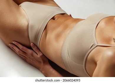 Perfect sportive shape of belly. Adorable body of young woman isolated on grey studio background. Fit, healthy and strong authentical body. Natural beauty, treatment, healthcare, fitness concept.
