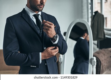 Perfect Style. Close Up Of Young Man In Full Suit Adjusting Sleeve While Standing Indoors          