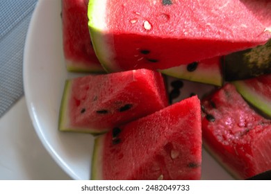 A perfect summer fruit! Whole watermelon with dark green stripes and a vibrant red interior, full of juicy flesh and black seeds. Ideal for refreshing drinks, delicious snacks, and poolside picnics - Powered by Shutterstock