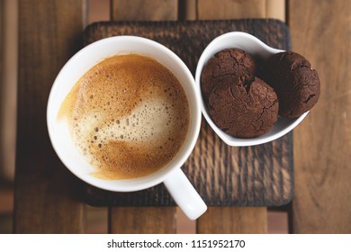 The perfect tasty breakfast Chocolate cookies with dark chocolate and sea pink Himalayan salt and cup of coffee on a wooden background