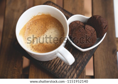 The perfect tasty breakfast Chocolate cookies with dark chocolate and sea pink Himalayan salt and cup of coffee on a wooden background