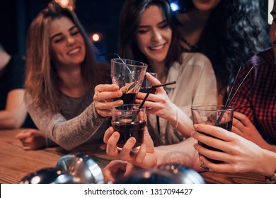 Perfect time spending for the youth. Group of young friends smiling and making a toast in the nightclub.