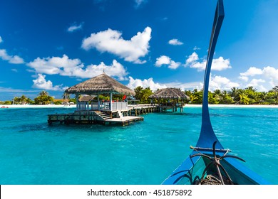 Perfect tropical island paradise beach Maldives. Long jetty and a traditional boat dhoni.