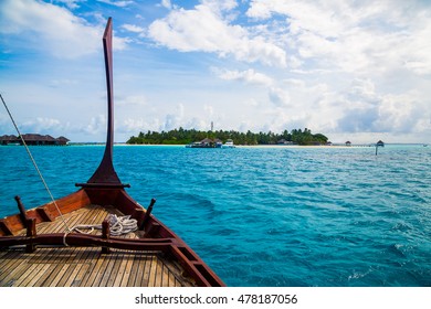 Perfect tropical island paradise beach Maldives. Long jetty and a traditional boat dhoni near the island.