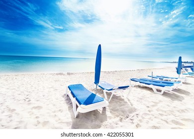 Perfect tropical paradise beach / Vacation holidays background wallpaper  with lounge chairs and  tents
