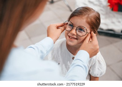 Perfect Vision. Woman And Girl Is In The Glasses Store Choosing Eyewear Together.