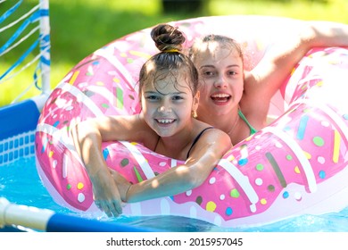 The Perfect Way To Stay Cool. Happy Kids Swim In Donut Pool Float. Pool Games. Poolside Play. Summer