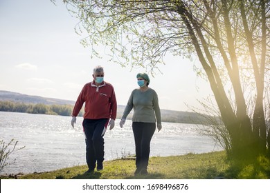 Perfect weekend for a stroll. Senior couple walking trough nature with mask on face. - Powered by Shutterstock