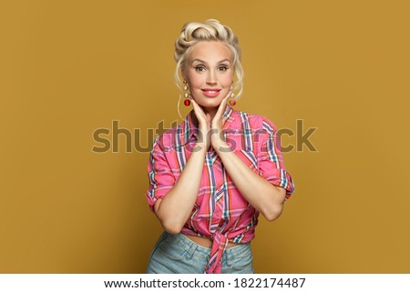 Perfect young Pin-up model woman posing on yellow background