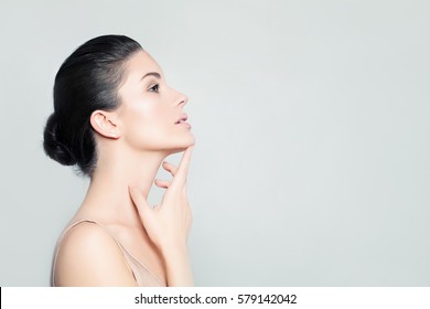 Perfect Young Woman Spa Model with Healthy Skin touching her Hand Her Face. Spa Beauty, Facial Treatment and Cosmetology Concept