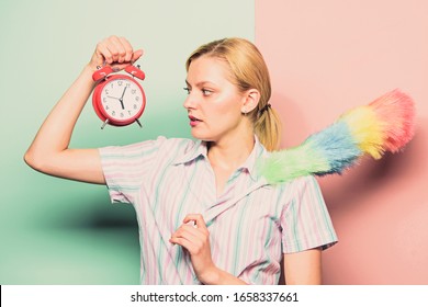 Perfectionism concept. Woman hold dust brush alarm clock. Everything must be perfect. Girl perfectionist. Perfectionist complex. Obsessive compulsive disorder. Cleaning time. Obsessed perfectionist.