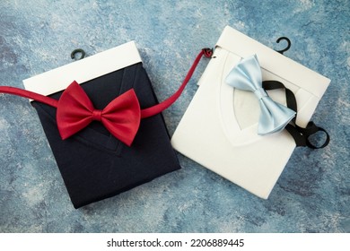 Perfectly Folded White And Navy Colour V Neck T-shirts Placed With Red And Blue Bow Tie. Top View