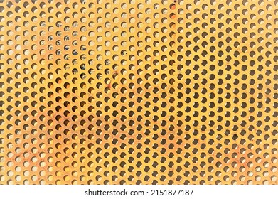 Perforated Metal Sheet. Peach Background. 