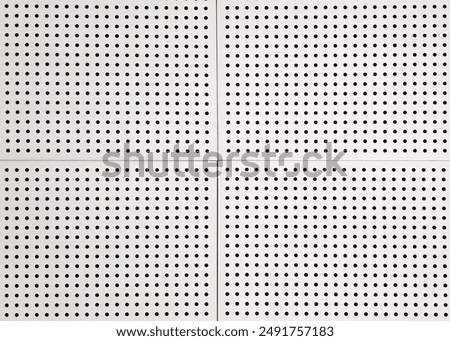 The perforated patterned ceiling made from zinc material installed on the office roof looks clean white with a dotted motif