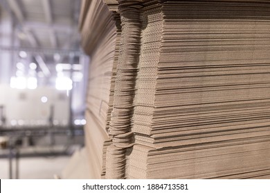 Perforated sheets of corrugated cardboard by stack on pallets - after assembly it will be cardboard boxes. Packaging of finished products in industrial production.