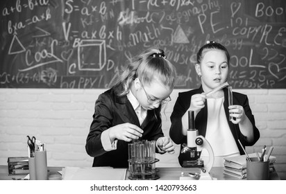 Perform chemical reactions. Basic knowledge of chemistry. Make studying chemistry interesting. Educational experiment concept. Girls classmates study chemistry. Microscope and test tubes on table.