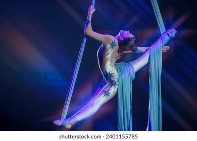 Performance by a circus acrobat artist. Girls perform aerial acrobatic elements on fabric. - Powered by Shutterstock - Get 15% off with code: PIKWIZARD15