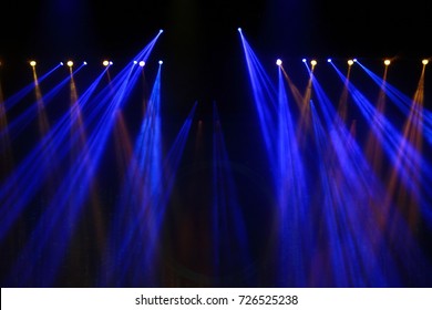 Performance moving lighting on construction light beam ray downward in yellow blue color, on Concert and Fashion Show stage ramp