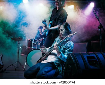 Performance of the rock band. The guitarist plays solo. The bass player plays solo. Drummer. Bass drum. Close-up. - Powered by Shutterstock