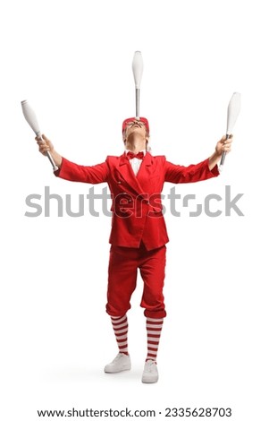 Performer in a red suit holding juggling clubs with head isolated on white background