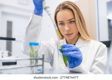 Performing sample transfer with precision pipette of plant extract in a pharmaceutical laboratory.