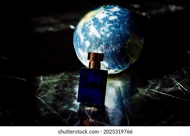 perfume in a blue bottle on the background of a mock-up of the earth. ecological concept. caring for the planet