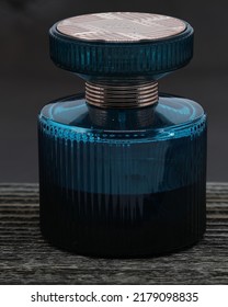 Perfume in a blue bottle.  Photographed using a wooden coffee table on a leather background