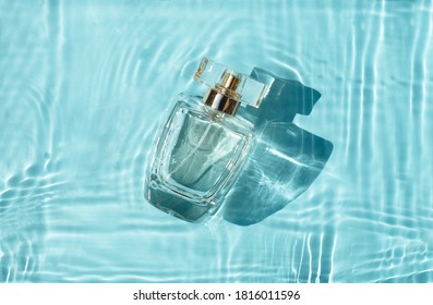 Perfume bottle in blue water with shadows. Top view  - Shutterstock ID 1816011596