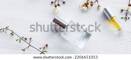 perfume bottle and different perfume bottles elegant for product presentation with realistic decorative flowers on white wooden background