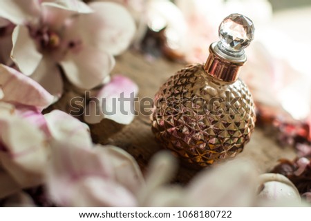 Perfume bottle. Gold perfumes. Gold bottle. Aroma. Perfumes for woman. Spring flowering branches, pink flowers, no leaves, blossoms Almond isolated on white background