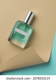 Perfume Bottle On Beige And Blue Paper Background. The Concept Of Natural Cosmetics. Flat Lay.