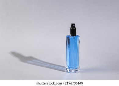Perfume Bottle On Gray Background With Long Shadow. Minimal Beauty Still Life