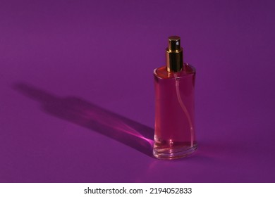 Perfume Bottle On Purple Background With Long Shadow. Minimal Beauty Still Life