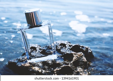 Perfume bottle on rock against sea water