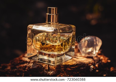 Perfume bottle on wooden surface against black background