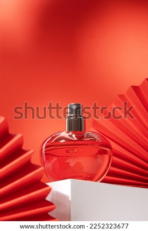 Perfume bottle with paper fan. Concept of expensive perfume and cosmetics. Floral fragrance for women. Perfume spray. Modern luxury lady parfum de toilette