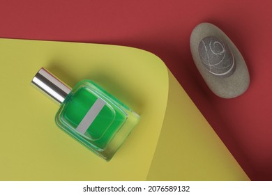 A Perfume Bottle And A Set Of Stones On A Red And Yellow Background. The Concept Of Natural Cosmetics. Flat Lay.