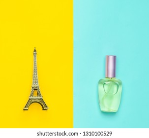 Perfume bottle, a statuette of the Eiffel tower on a multicolored paper background, top view, minimalism