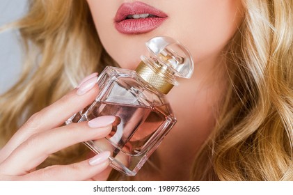Perfume bottle woman spray aroma. Woman holding a perfumes bottle. Womans with perfum bottle. Beautiful girl using perfume. Woman with bottle of perfume. Woman presents perfumes fragrance.