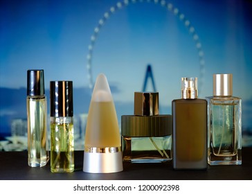 Perfume bottles of different shapes photographed with a Ferris wheel in the background.