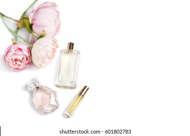 Perfume Bottles With Flowers On Light Background. Perfumery, Cosmetics, Fragrance Collection. Free Space For Text.