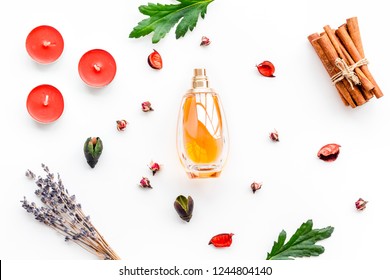 Perfume With Bright Fruity, Floral, Spicy Fragrance. Ingredients For Perfume. Bottle Of Perfume Near Dry Flowers, Cinnamon And Candles On White Background Top View Pattern