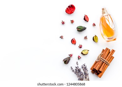 Perfume With Bright Fruity, Floral, Spicy Fragrance. Ingredients For Perfume. Bottle Of Perfume Near Dry Flowers, Cinnamon And Candles On White Background Top View Pattern Space For Text