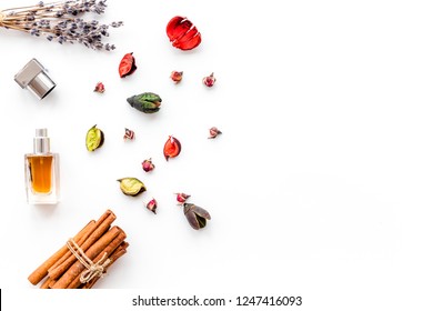 Perfume With Bright Fruity, Floral, Spicy Fragrance. Ingredients For Perfume. Bottle Of Perfume Near Dry Flowers, Cinnamon And Candles On White Background Top View Pattern Space For Text