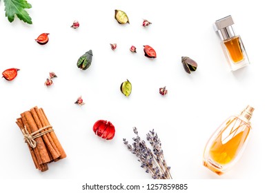 Perfume With Bright Fruity, Floral, Spicy Fragrance. Ingredients For Perfume. Bottle Of Perfume Near Dry Flowers, Cinnamon And Candles On White Background Top View Pattern