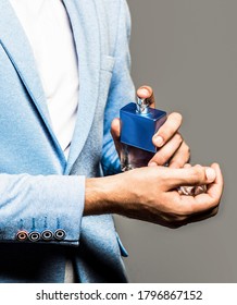 Perfume Or Cologne Bottle. Male Fragrance And Perfumery, Cosmetics. Man Perfume, Fragrance. Masculine Perfume. Man Holding Up Bottle Of Perfume.