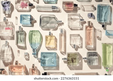 Perfume and eau de toilette bottles flatlay a lot, collection top view. Beautiful multicolored perfume bottles on a beige background, holiday gifts of choice. - Shutterstock ID 2276363151