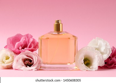 Parfüm und Blumen auf buntem Hintergrund.
